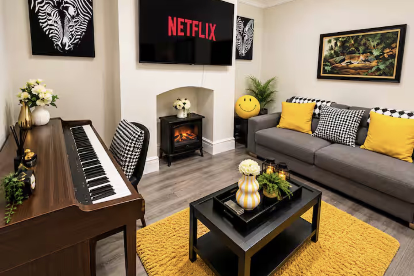 Cosy lounge with a piano, fireplace and yellow accents