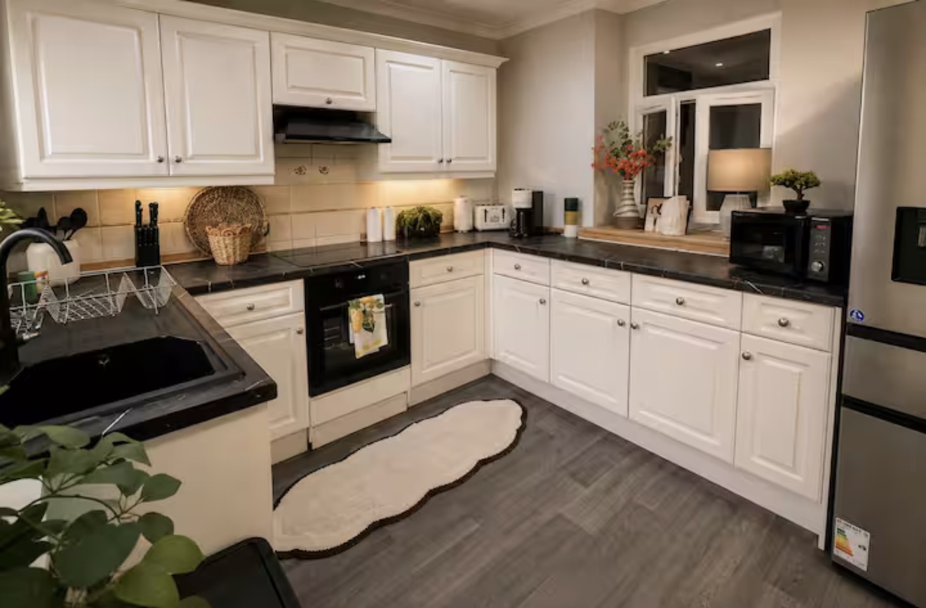 White kitchen with dark worktops and fitted appliances