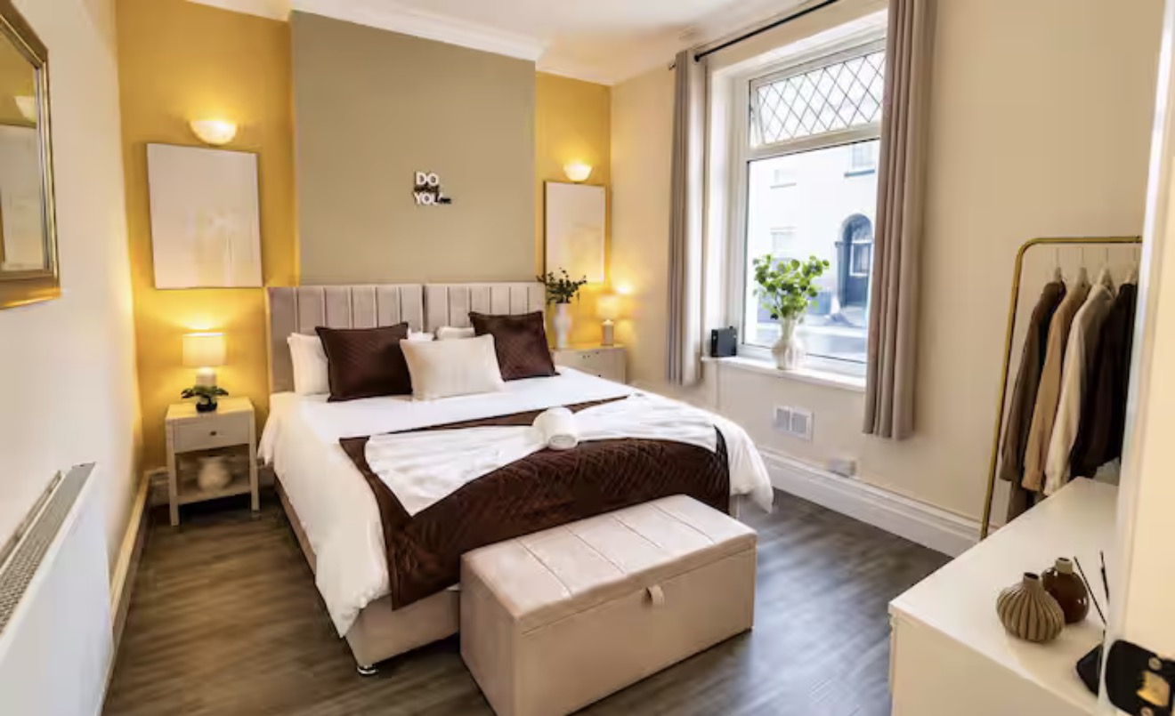 Double bedroom with gold accents and a large window